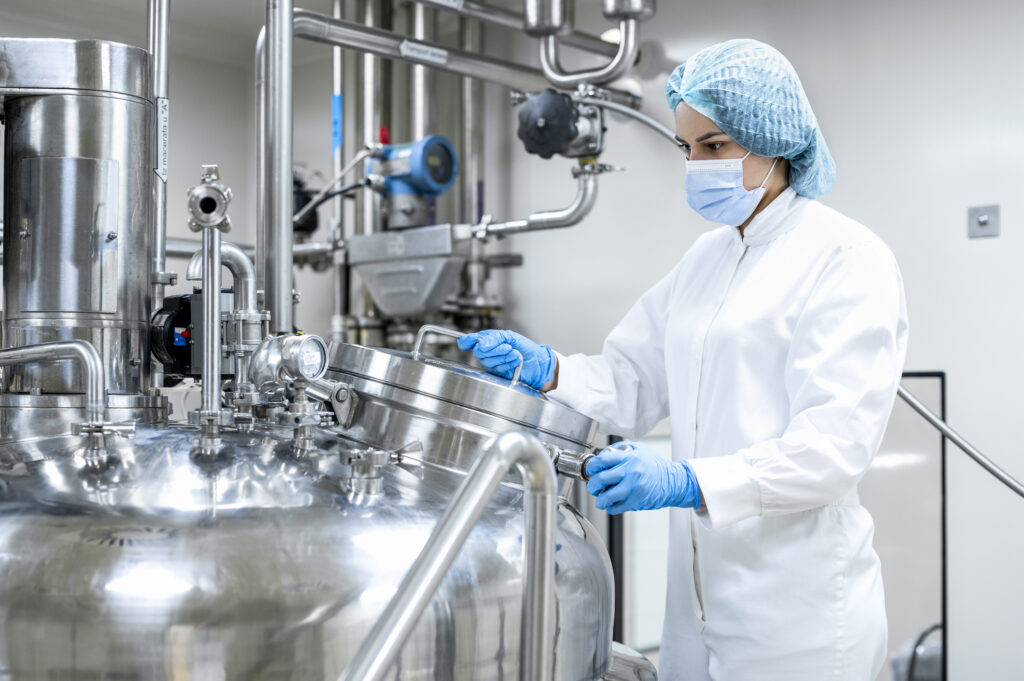 Worker in a chemical manufacturing plant prepares to inspect the product. 