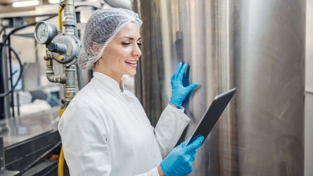 Dairy factory worker reviewing process efficiency. 